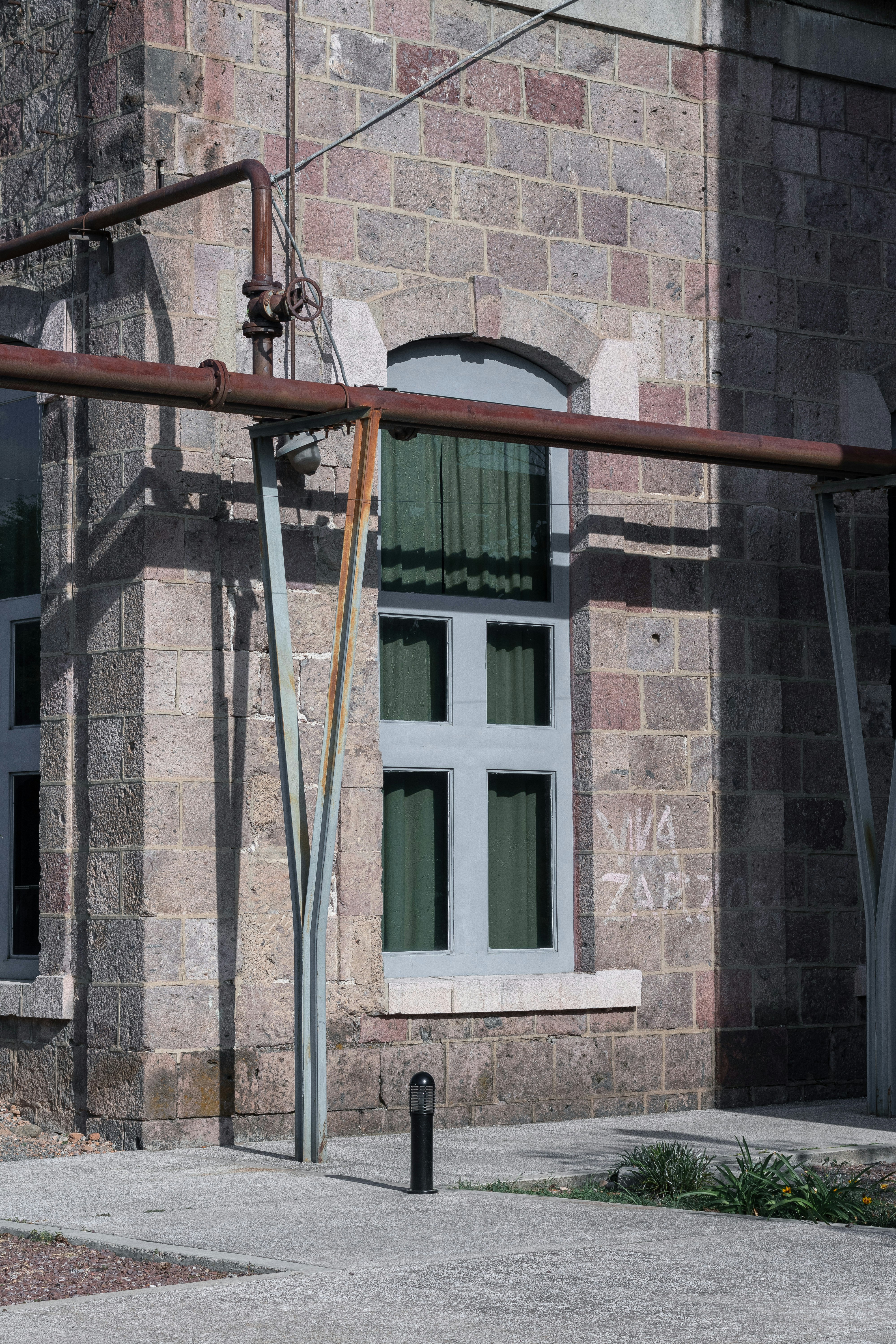 brown metal ladder near brown brick building